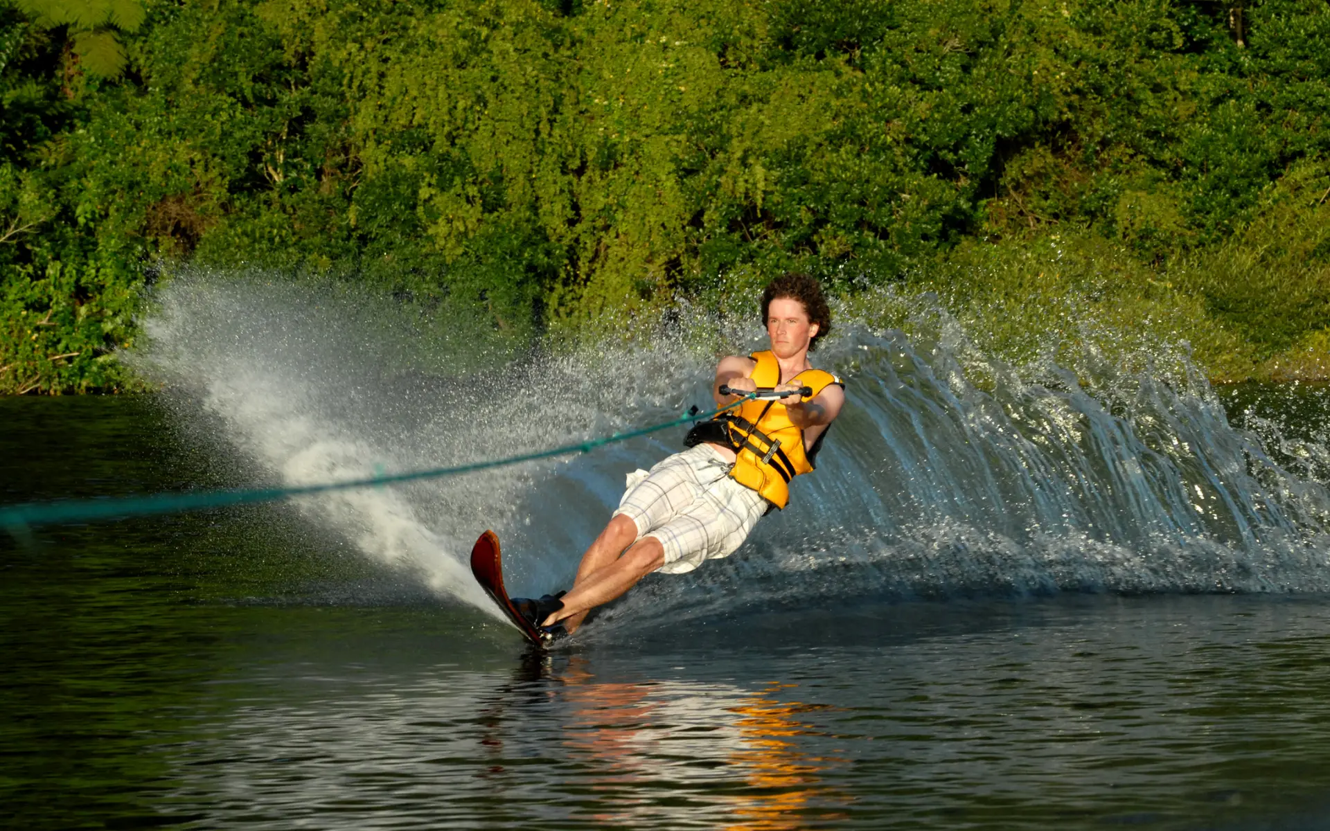 A camper water skiing through a spray of lake water